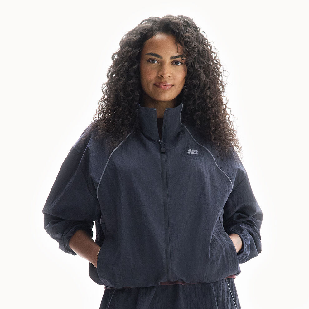 Sydeon, a New Balance ambassador, standing in the Trackside Woven jacket. 